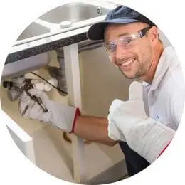 Encanador comercial realizando reparo hidráulico e troca de válvula em empresa.