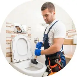 Encanador industrial realizando manutenção hidráulica em linha de produção.