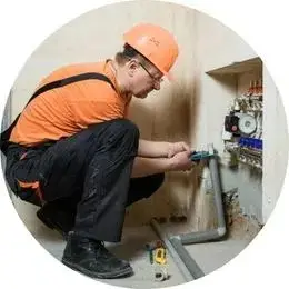 Encanador comercial em São Bernardo do Campo realizando manutenção hidráulica em empresa com ferramentas profissionais.